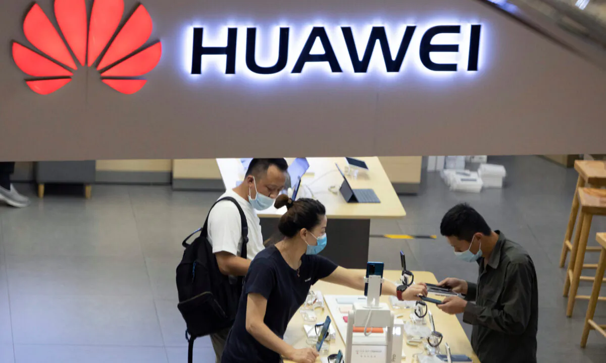Visitors wearing masks to curb the spread of the coronavirus look at the latest products at a Huawei store in Beijing, China, on July 15, 2020 (Ng Han Guan/AP Photo)