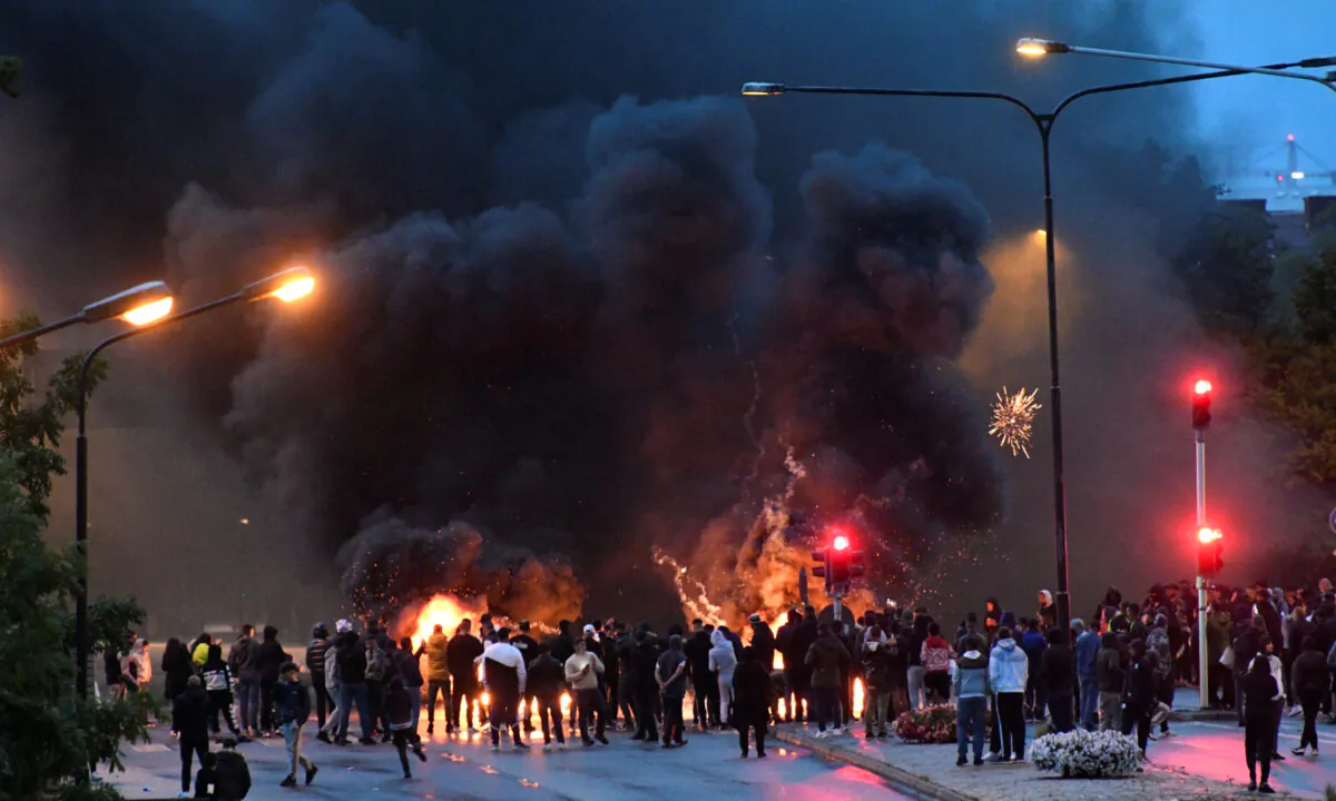 Smoke billows from the burning tyres, pallets, and fireworks during a riot in the Rosengard neighborhood of Malmo, Sweden on Aug. 28, 2020. (TT News Agency via Reuters)
