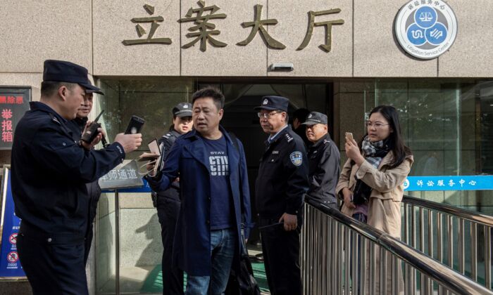 Lawyer Xie Yang (center) and his client Xu Yan (right), wife of human rights lawyer Yu Wensheng, try to meet with Yu outside the Xuzhou Intermediate Court in Xuzhou, in eastern China’s Jiangsu Province, on Oct. 31, 2019. (Nicolas Asfouri/AFP via Getty Images)