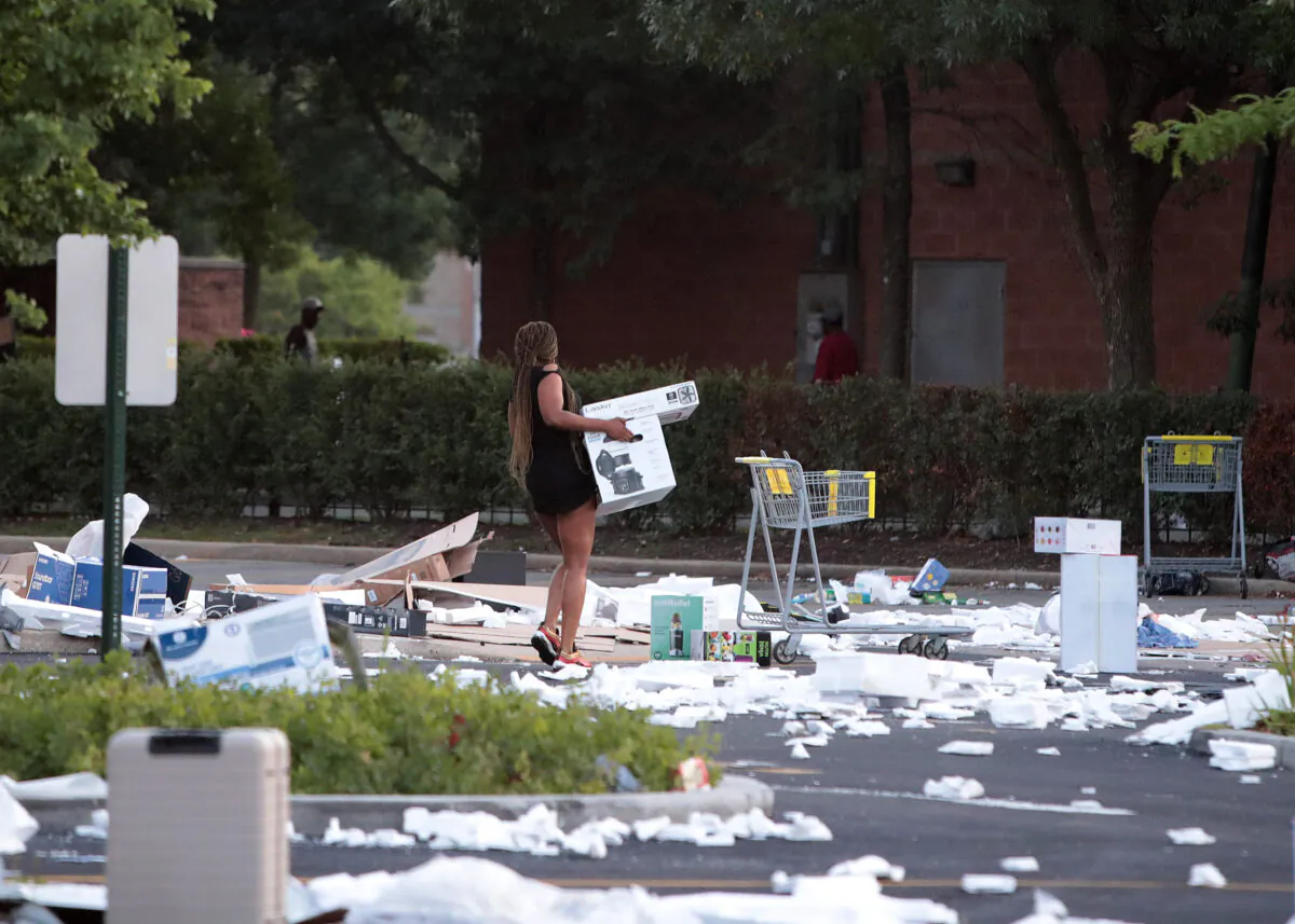 A person carries a box near a looted Best Buy store in Chicago, Ill., on Aug. 10, 2020. (Scott Olson/Getty Images)