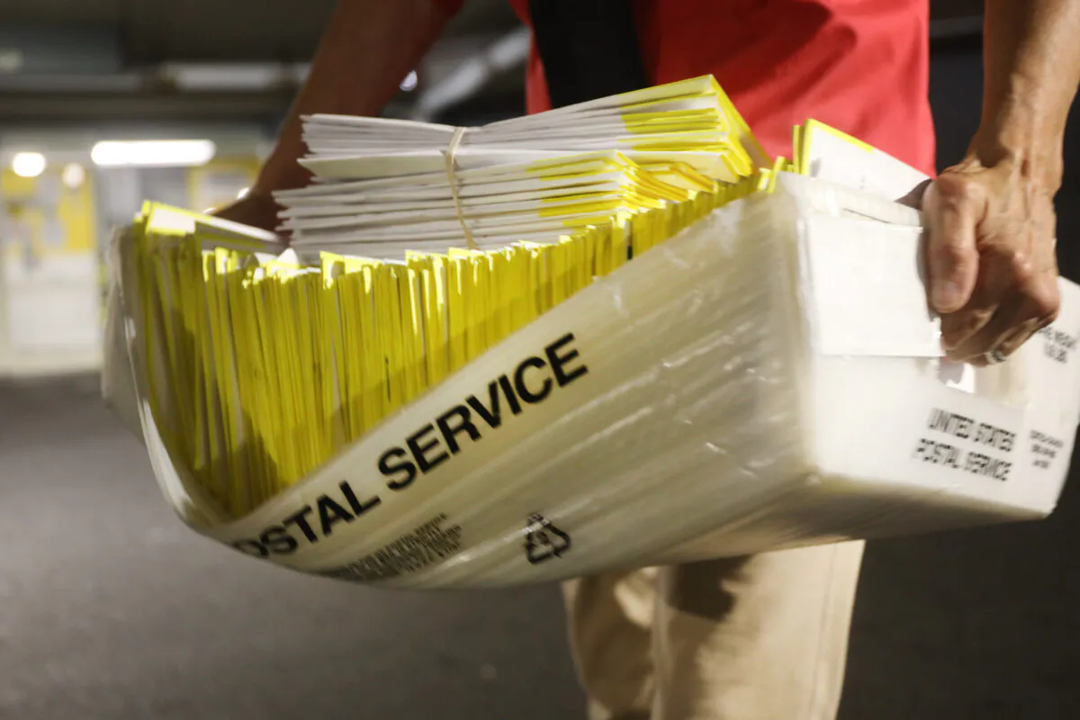 In this file photo, a polling worker holds 2020 presidential primary ballots that were dropped at a post office and brought to a government center to be processed and counted at the Stamford Government Center in Hartford, Connecticut, on Aug. 11, 2020. (Spencer Platt/Getty Images)