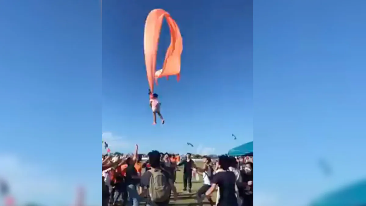 A 3 year old girl is lifted into the air by a large kite during a kite festival in Hsinchu, northern Taiwan, on Aug. 30, 2020. (Dainese Hsu/AP Photo)