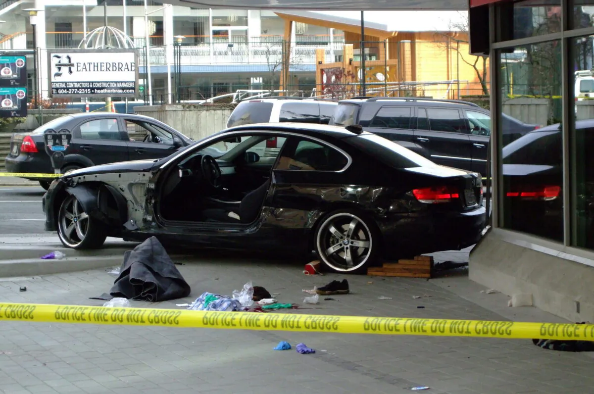 A black BMW sits crashed into the new CBC building after an apparent carjacking in Vancouver, Canada, on Dec. 29, 2009. (Ash Mishra/The Canadian Press)