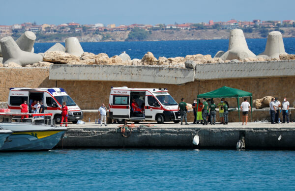 Emergency services are seen on the dock of Le Castella after a migrant boat caught fire during rescue operations off the coast of Crotone