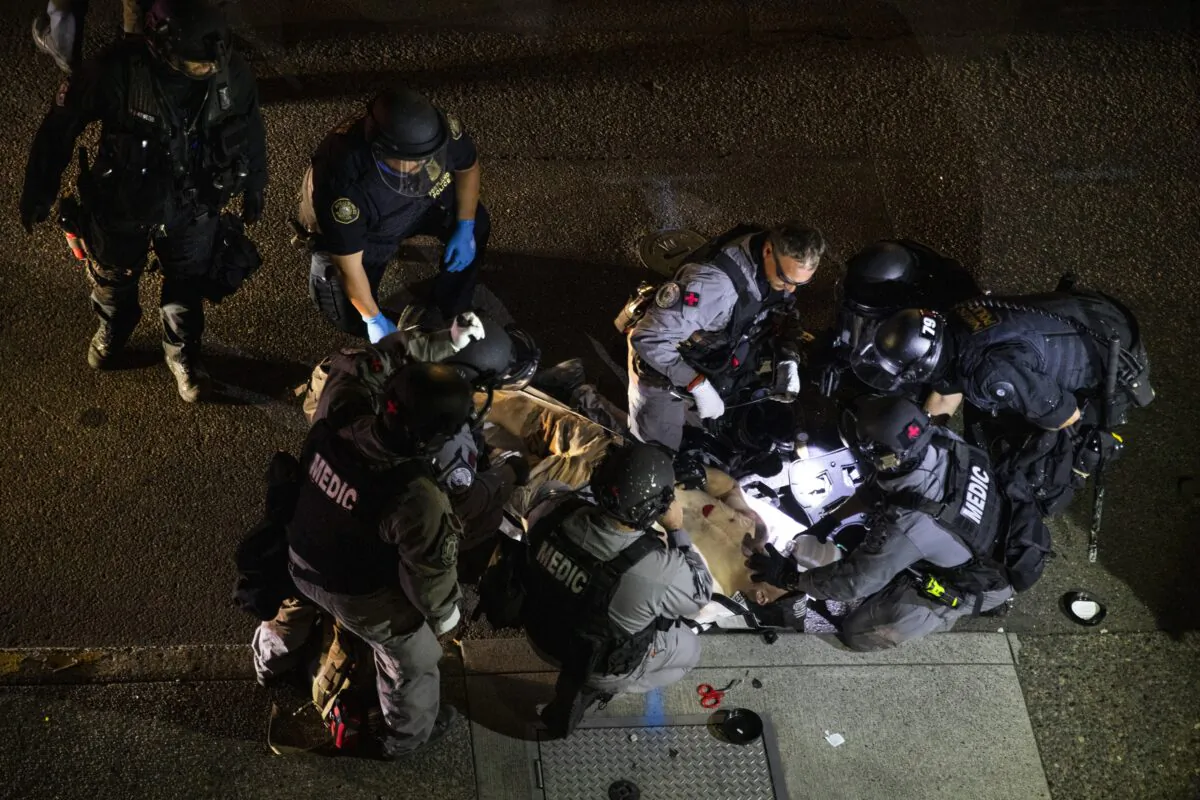 A man is treated after being shot in Portland, Ore., on Aug. 29, 2020. The victim, identified as Aaron Danielson, died. (Paula Bronstein/AP Photo)