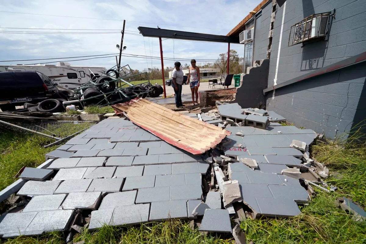 Monique Benjamin, left, and her 17-year old daughter Amiah Winbush look at the damage to their car detailing business, in Lake Charles, La., on Aug. 30, 2020. (Gerald Herbert/AP Photo)