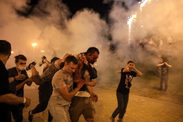 Protesters carry a wounded man during clashes with police