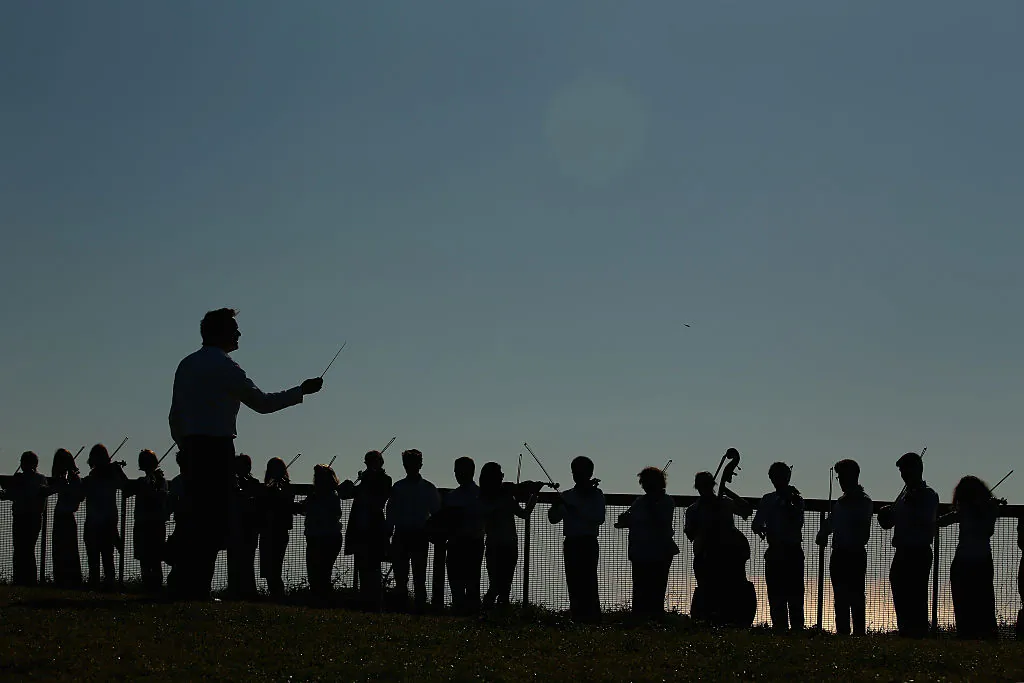 Roger Benedict, the conductor and director conducts as musicians form human wall on a cliff near Macquarie Lighthouse representing standing in the way of suicide to raise awareness for the upcoming Concert For Life on August 21, 2015 in Sydney, Australia. (Mark Kolbe/Getty Images)