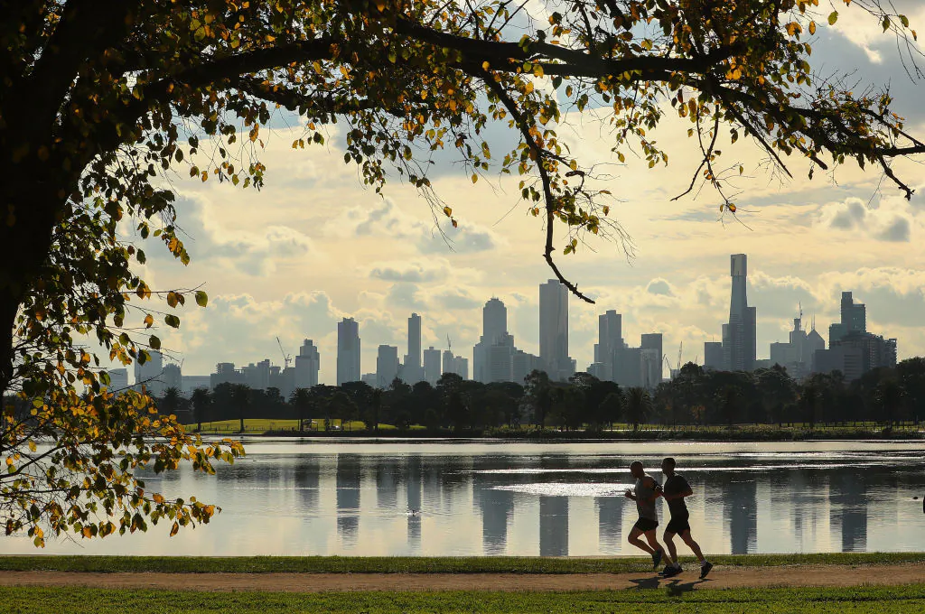 Two joggers run along Albert Park Lake on an Autumn day with  high-rise and apartment buildings in the city in the background on June 16, 2017 in Melbourne, Australia. (Scott Barbour/Getty Images)