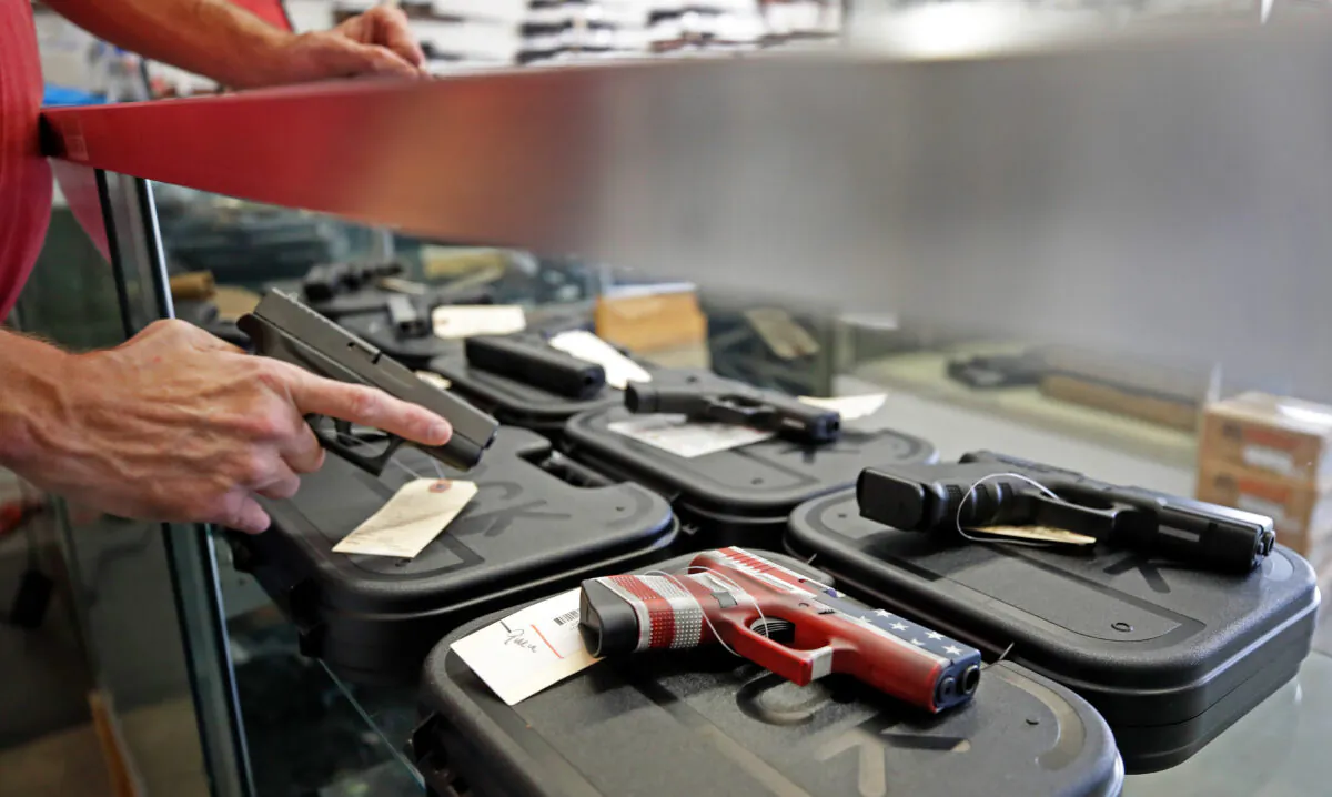 A worker restocks handguns at Davidson Defense in Orem, Utah, on March 20, 2020. (George Frey/AFP via Getty Images)