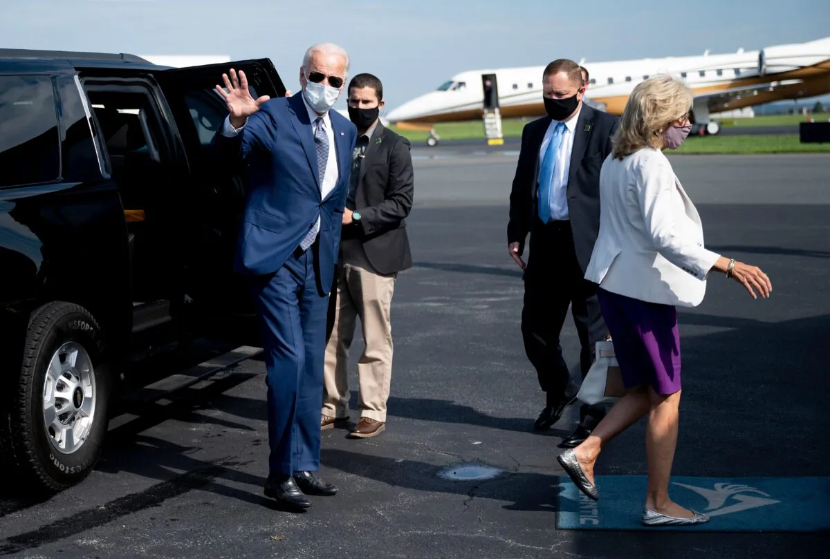 Democratic presidential candidate Joe Biden, with his wife Dr. Jill Biden (R), waves as he boards his plane in New Castle, Del., on Sept. 3, 2020. (Jim Watson / AFP via Getty Images)