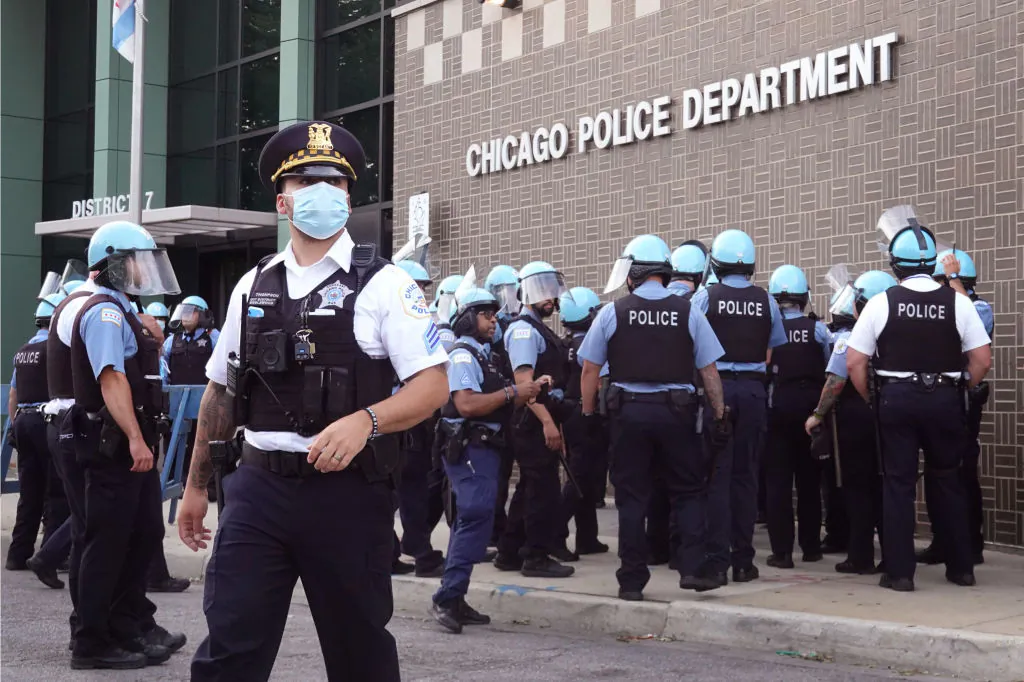 Chicago police stand guard as demonstrators protest outside the department's 7th District station in Chicago, Illinois, on Aug. 11, 2020. The protest was held in response to the August 9 shooting and wounding of a 20-year-old man who allegedly fired at officers in the Englewood neighborhood. The protest was met with resistance from a small group of Englewood residents.  (Scott Olson/Getty Images)