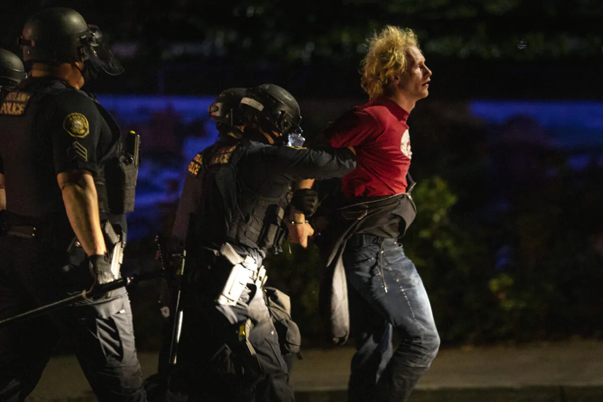 Portland police officers arrest Kristopher Michael Donnelly amid rioting outside a police precinct, in Portland, Ore., Aug. 30, 2020. (Paula Bronstein/AP Photo)