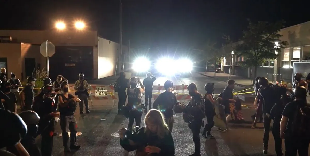 In this still image from video, demonstrators face off with police vehicles on a street near the Portland Police Bureau's North Precinct, in Portland, Ore., on Sept. 2, 2020. (Roman Balmakov/The Epoch Times)