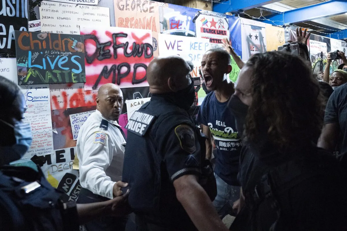 Demonstrators confront police officers during a rally to protest President Donald Trump's acceptance of the Republican National Convention nomination at Black Lives Matter plaza across from the White House in Washington on Aug. 27, 2020. (Jose Luis Magana/AFP via Getty Images)