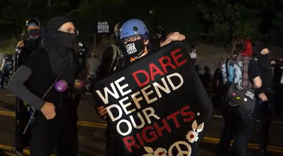 In this still image from video, demonstrators stand near the Penumbra Kelly Building in Portland, Ore., on Sept. 3, 2020. (Roman Balmakov/The Epoch Times)