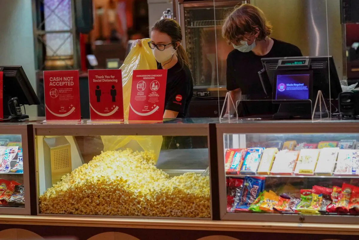 Concessions workers stock the bins with popcorn and other treats as the theatre opens for some of the first showings at the AMC theatre when it re-opened for the first time since shutting down at the start of the COVID-19 pandemic, in West Homestead, Penn., on Aug. 20, 2020. (Keith Srakocic/AP Photo)