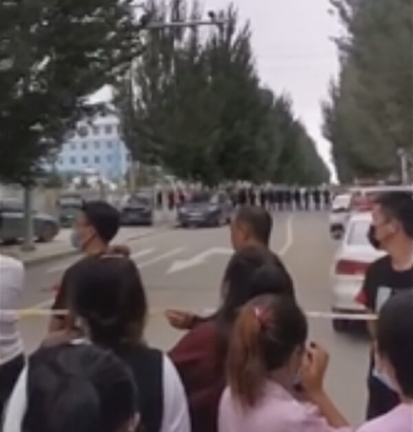 Parents gather behind a police line