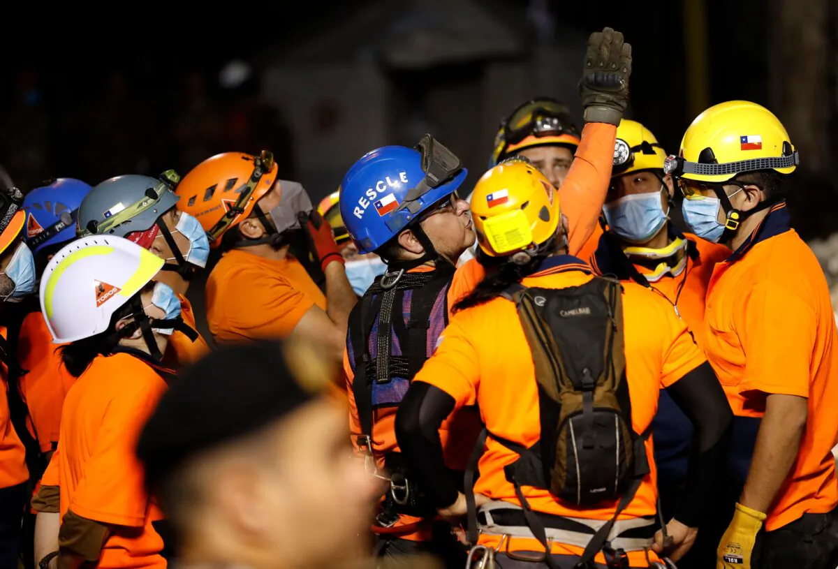 The leader of the Chilean rescuers, center, gives his team direction in where to start searching the site of a collapsed building after getting signals there may be a survivor under the rubble, in Beirut, Lebanon, on Sept. 4, 2020. (Hussein Malla/AP Photo)