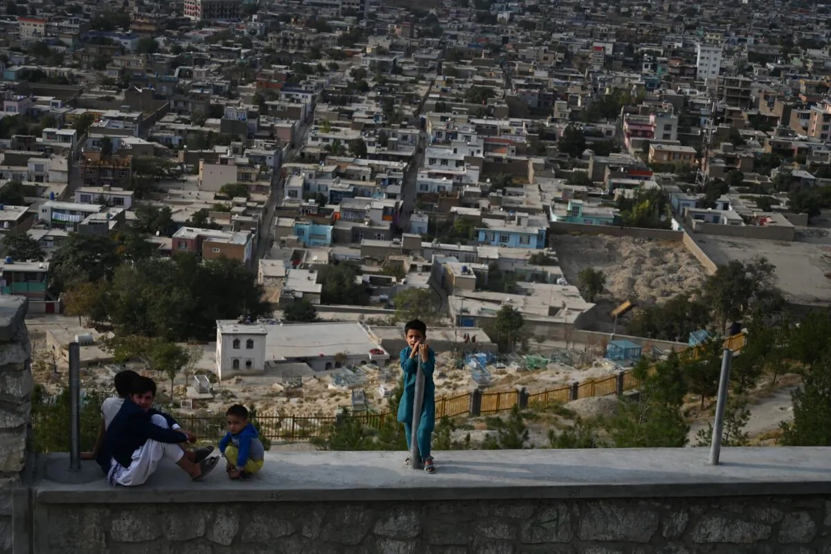 Children react as they sit on a path at Wazir Akbar Khan hilltop overlooking Kabul on Sept. 29, 2019. (Sajjad Hussain/AFP via Getty Images)