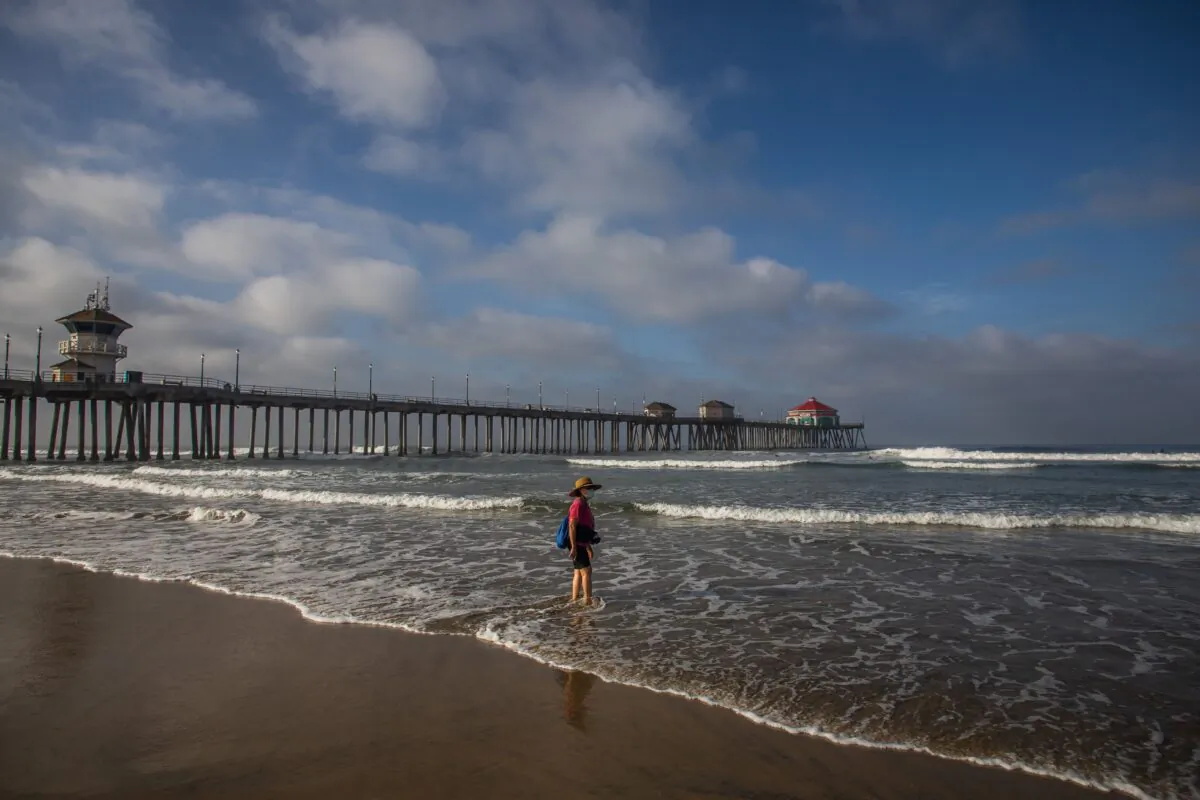 A woman wearing face masks watches the ocean in Huntington Beach, Calif., on May 02, 2020. (Apu GOMES/AFP via Getty Images)