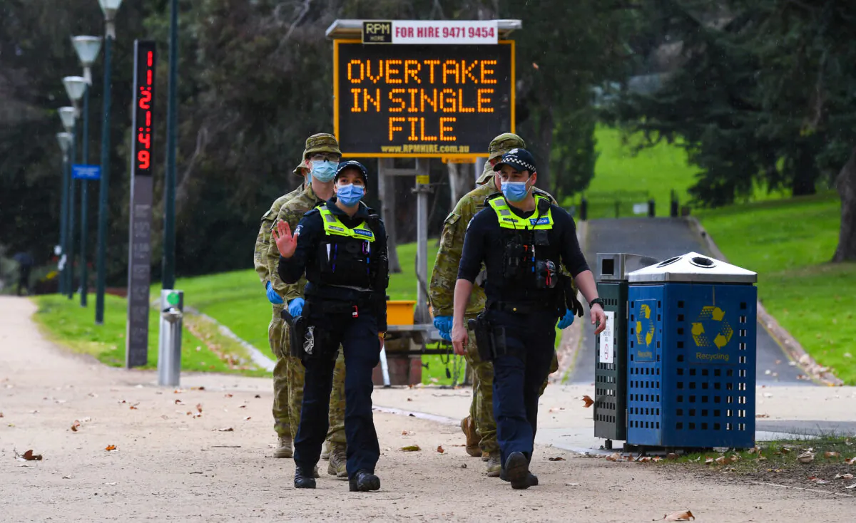 Police officers and soldiers patrol a popular running track in Melbourne, Australia on Aug. 4, 2020. William West / AFP via Getty Images)