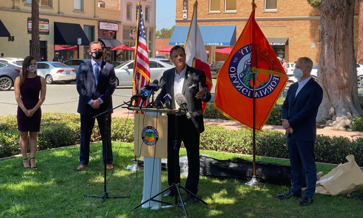 Orange County Supervisor Donald Wagner, center, speaks as Newport Beach Mayor Will O'Neill, left, and Lake Forest City Councilman Dwight Robinson, right, listen at a news conference calling for the expedited reopening of Orange County businesses and schools in Orange, Calif., on Sept. 4, 2020. (Drew Van Voorhis/The Epoch Times)