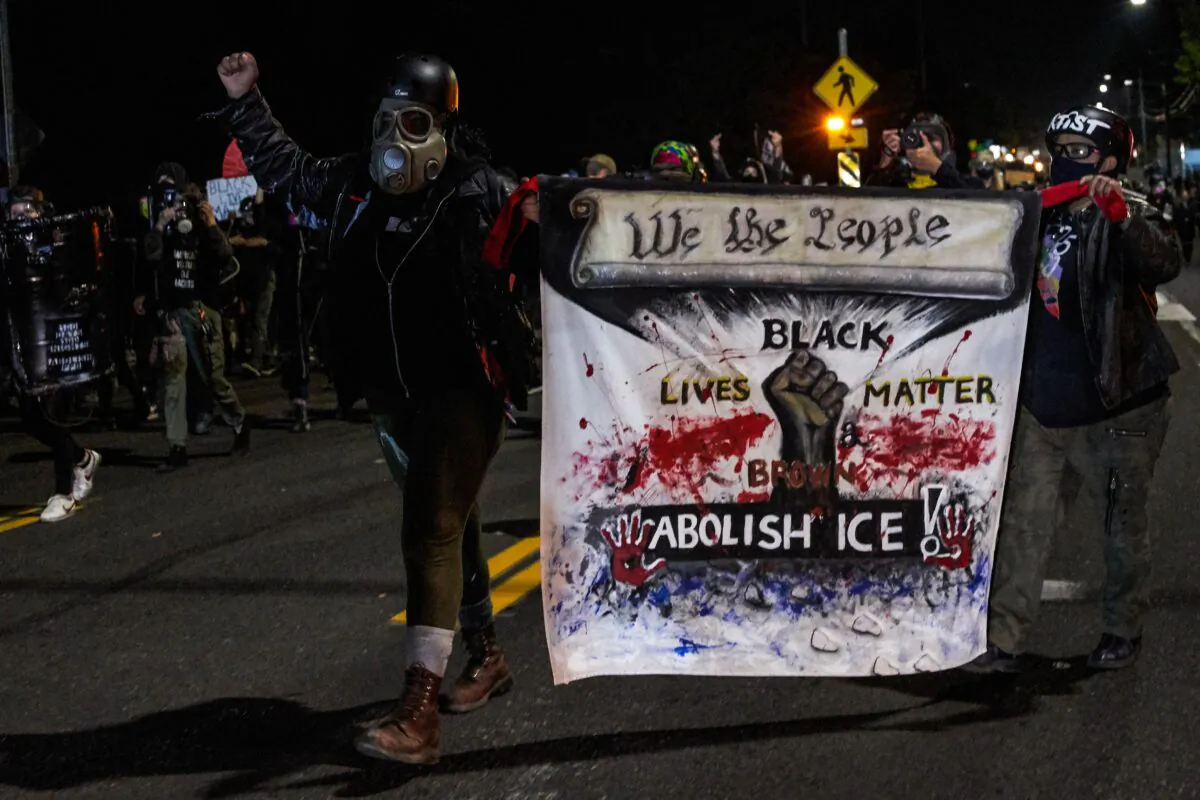 People carry a banner during a march that devolved into a riot in Portland, Ore., late Sept. 5, 2020. (Allison Dinner/AFP via Getty Images)