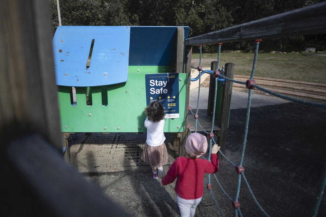 Children look at at COVID-19 related sign at Clovelly playground in Sydney, Australia on May 17, 2020. (Ryan Pierse/Getty Images)