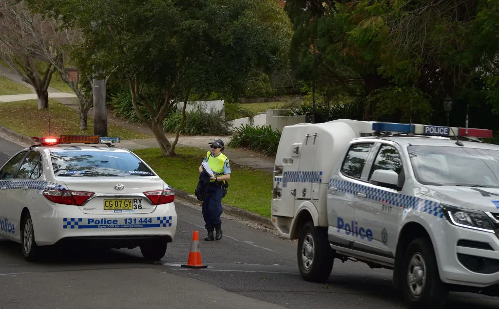 A policewoman is seen on a street where a father (known as John Edwards) shot dead his teenage son and daughter at their home in Sydney on July 6, 2018. (PETER PARKS/Getty Images)