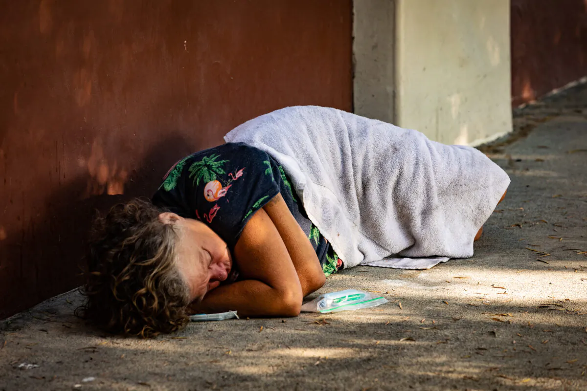 A homeless individual sleeps on the streets of Santa Ana, Calif., on Sept. 4, 2020. (John Fredricks/The Epoch Times)