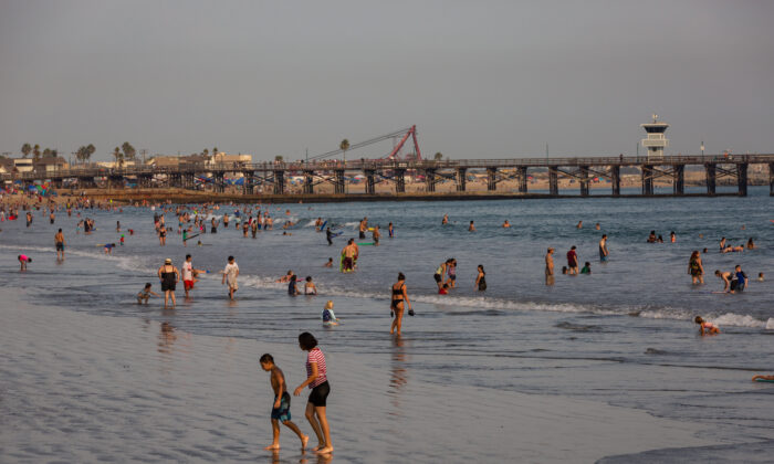 Beachgoers cool off in the ocean at Seal Beach, Calif., during a heat wave on Sept. 6, 2020. (John Fredricks/The Epoch Times)
