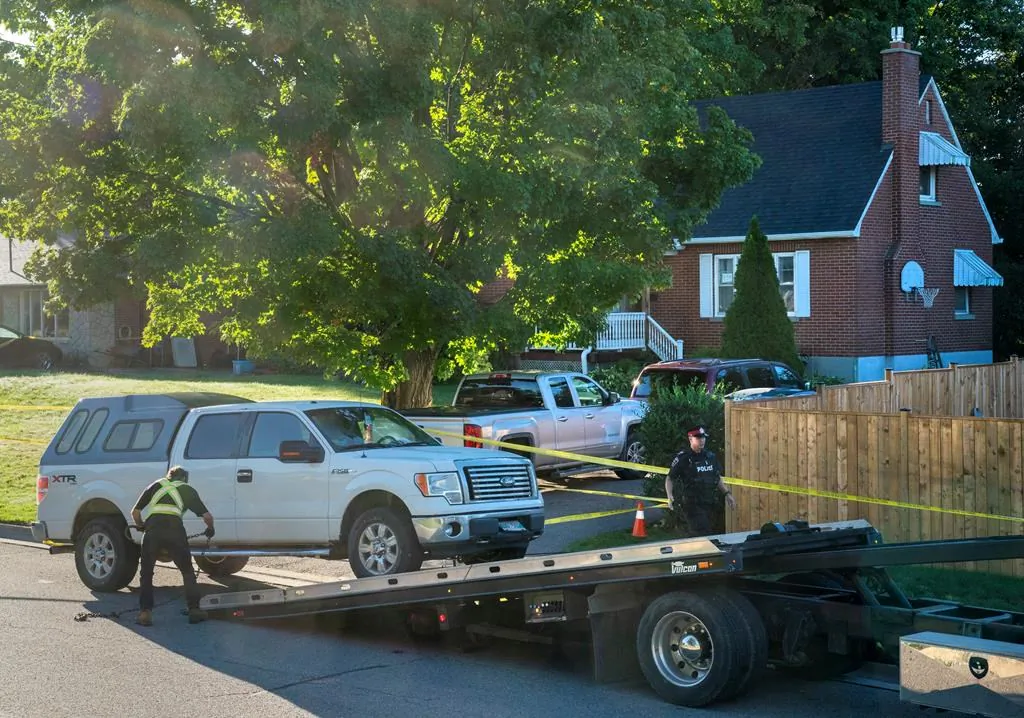 Police remove a truck with Manitoba licence plates from the front of a home on Parklane Avenue in Oshawa, Ont. on Sept. 4, 2020. (The Canadian Press/Frank Gunn)