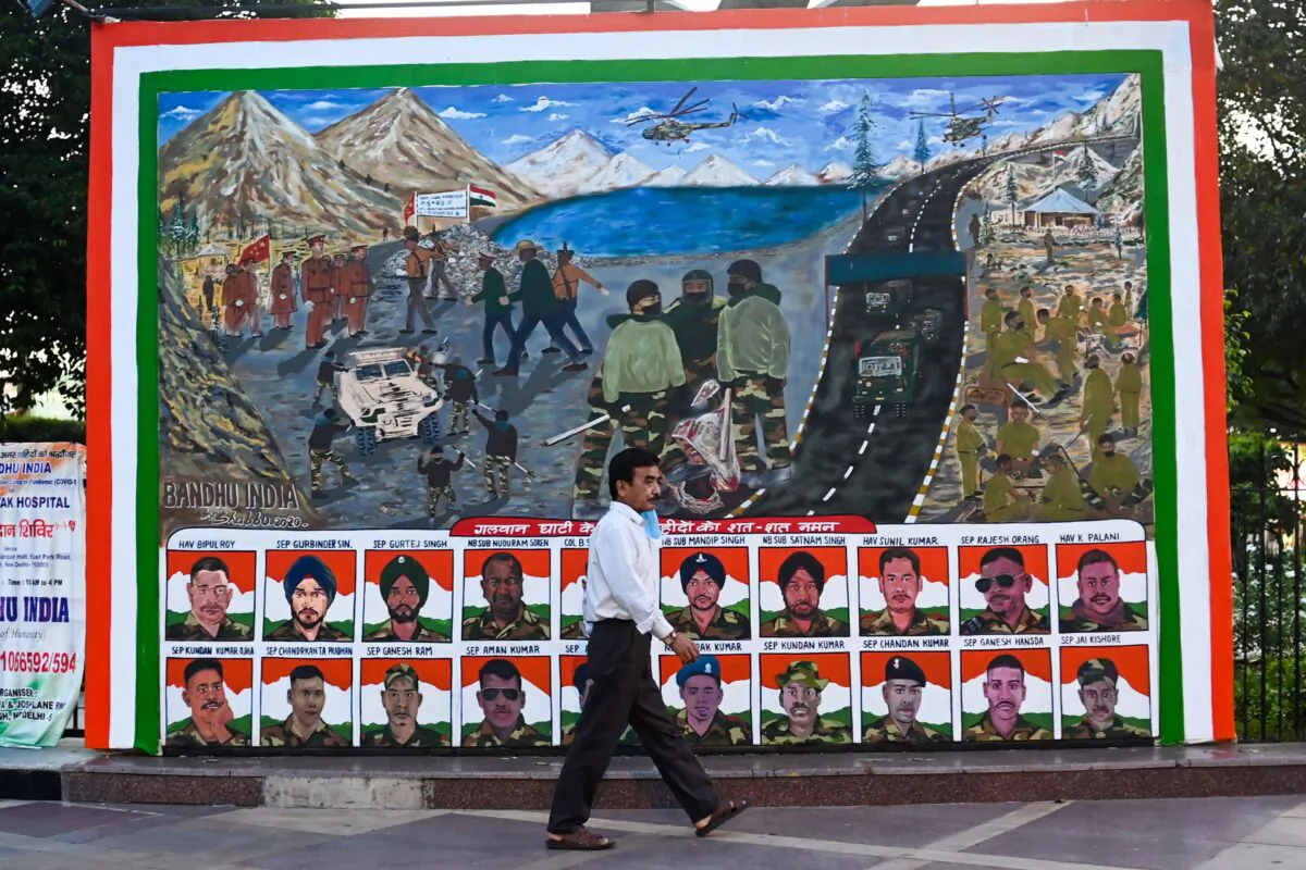 A man walks past a poster, depicting portraits of Indian soldiers killed in a hand-to-hand fight with their Chinese counterparts on June 15, 2020 in a market area in New Delhi on Aug. 31, 2020.   (Jewel Samad/AFP via Getty Images)