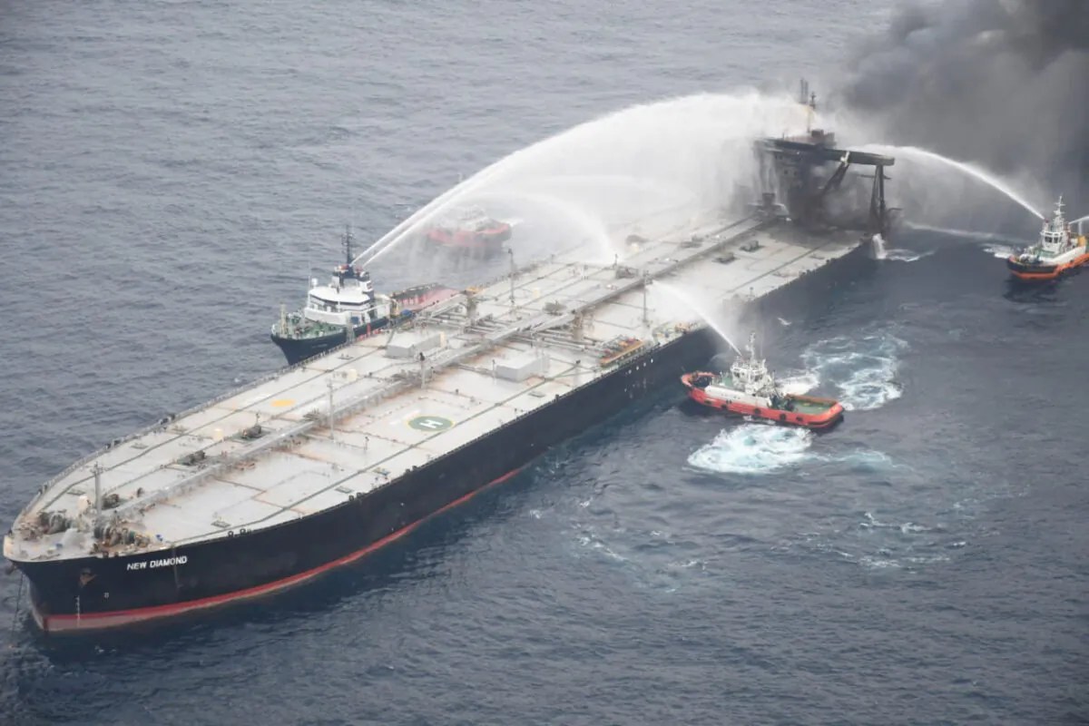 A Sri Lankan Navy boat sprays water on the New Diamond, a very large crude carrier (VLCC) chartered by Indian Oil Corp (IOC), that was carrying the equivalent of about 2 million barrels of oil, after a fire broke out off east coast of Sri Lanka, on Sept. 8, 2020. (Sri Lankan Airforce media/Handout via Reuters)