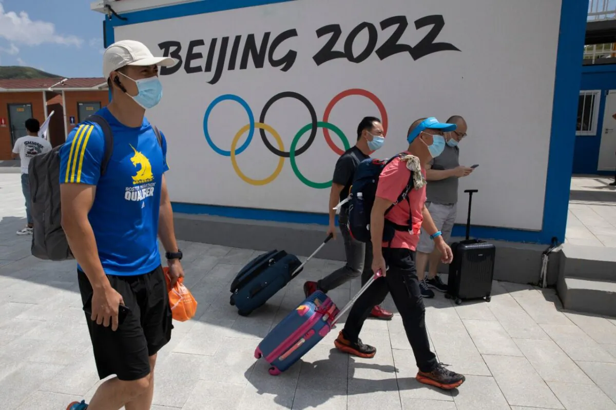 Visitors to Chongli, one of the venues for the Beijing 2022 Winter Olympics, pass by the Olympics logo in Chongli in northern China's Hebei Province on Aug. 13, 2020. (Ng Han Guan/AP Photo)