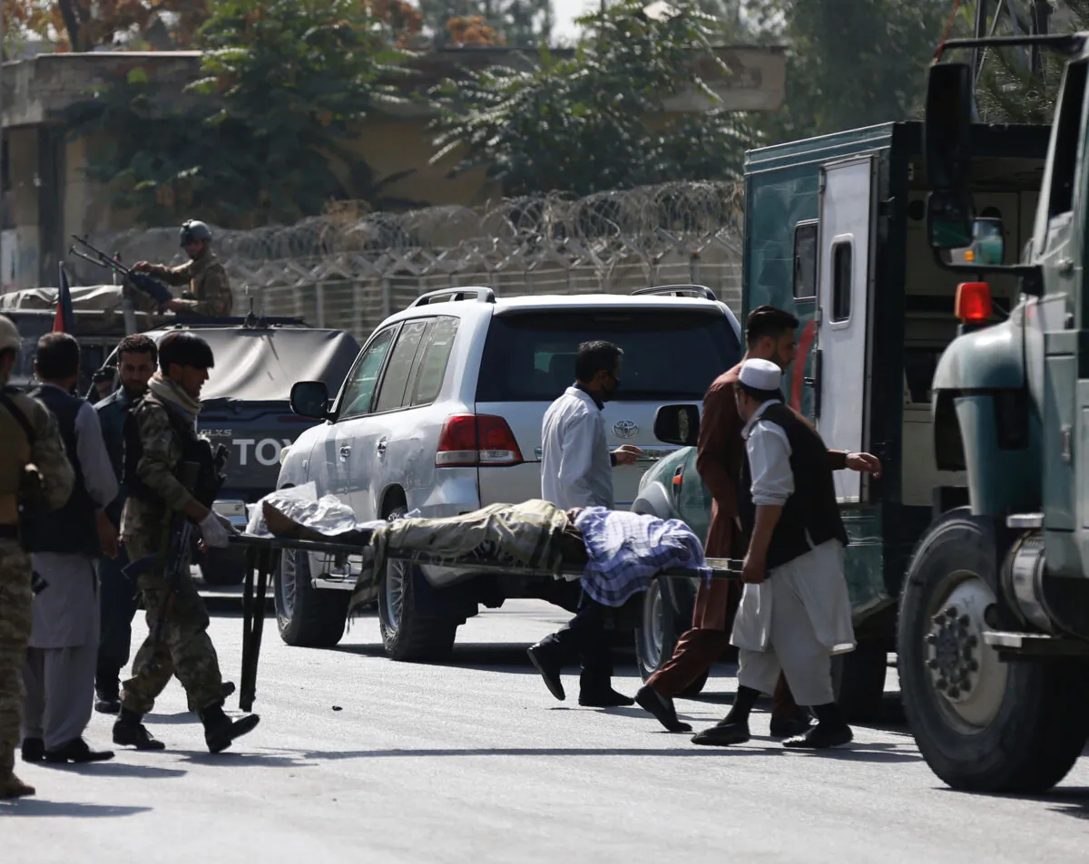 Afghan men carry a victim in a file photo taken after an attack in Afghanistan. (Mohammad Ismail/Reuters)