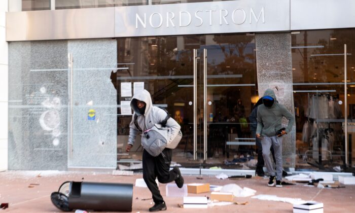 Thieves are seen looting stores at the Grove shopping center in the Fairfax District of Los Angeles, Calif., on May 30, 2020. (VALERIE MACON/AFP via Getty Images)