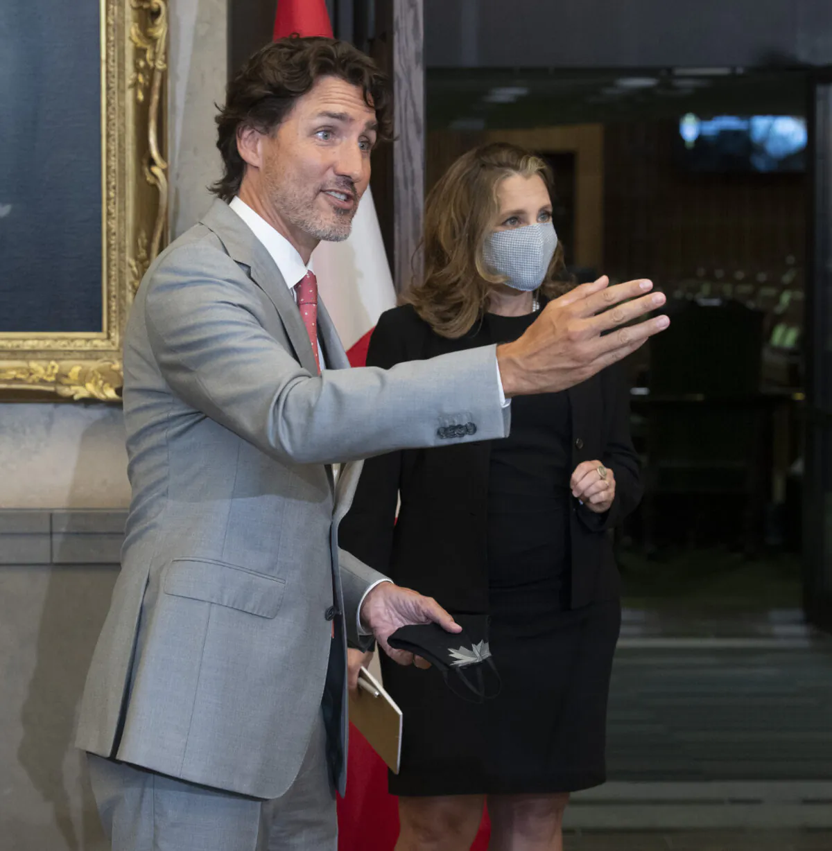 Prime Minister Justin Trudeau speaks with a reporter as Deputy Prime Minister and Minister of Finance Chrystia Freeland looks on during a news conference on Parliament Hill in Ottawa on Aug. 18, 2020. (The Canadian Press/Adrian Wyld)