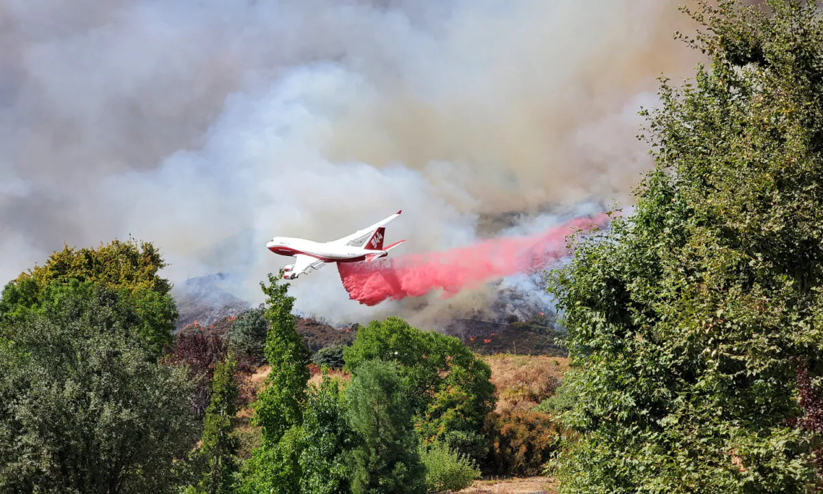 An airplane drops dampening material on a wildfire in San Bernardino County, Calif., on Sept. 5, 2020. (Courtesy of a local photographer on the scene)