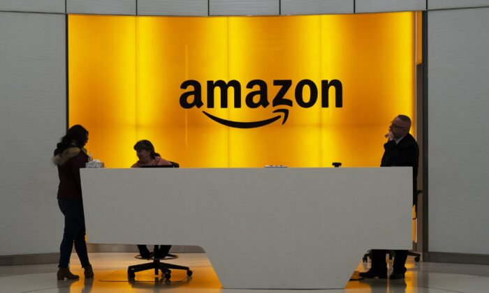People stand in the lobby for Amazon offices in New York, N.Y., on Feb. 14, 2019. (Mark Lennihan/AP Photo)
