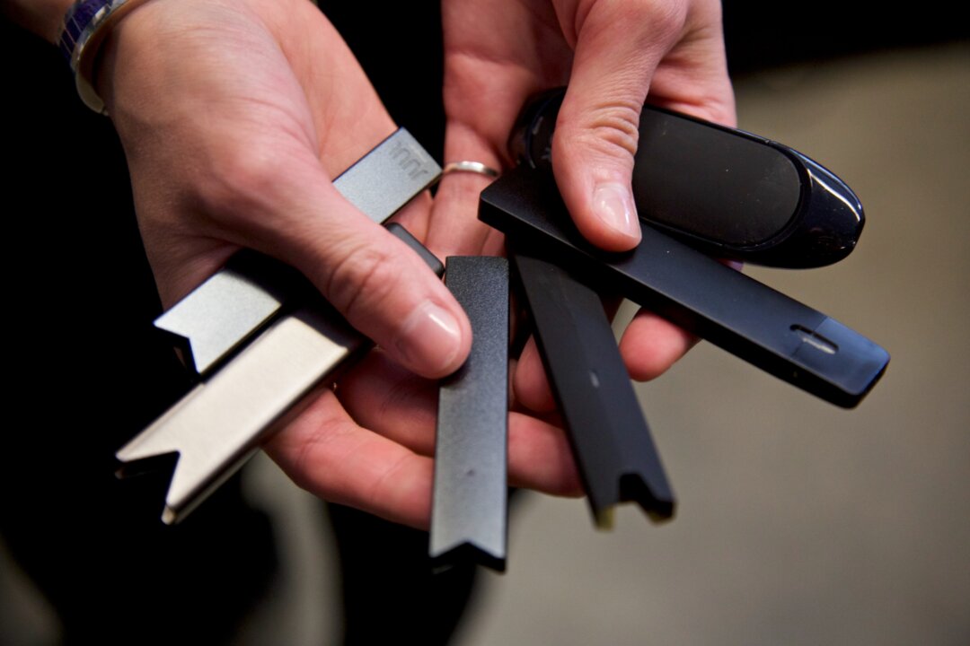A researcher holds vape pens in a laboratory in Portland, Ore., on April 16, 2019. (Craig Mitchelldyer/AP Photo)