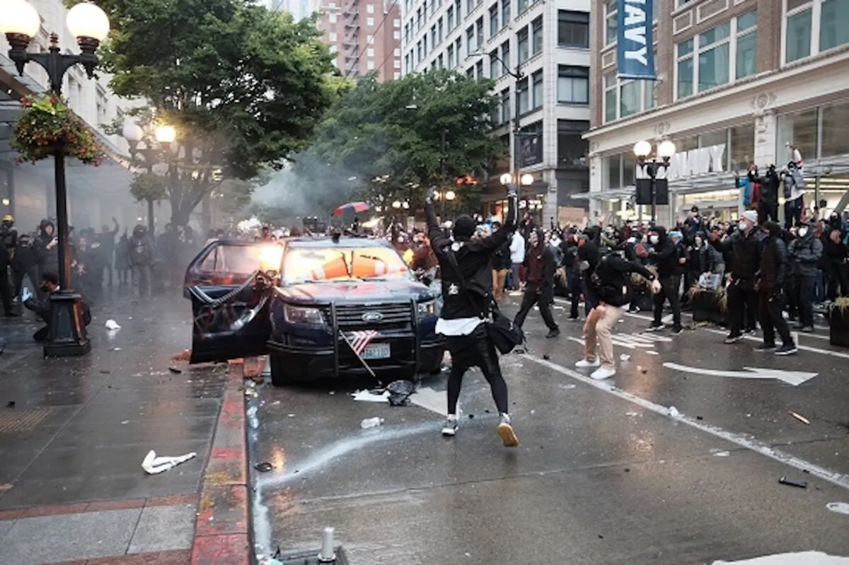 Image shows Kelly Thomas Jackson, 20, throwing a Molotov cocktail at a vehicle during a violent protest in downtown Seattle, Washington, on May 30. (US District Court for the Western District of Washington at Seattle)