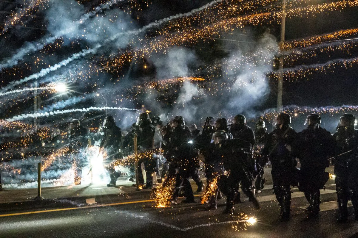 Oregon State Troopers and Portland police advance through tear gas while responding to a riot in Portland, Ore., on Sept. 5, 2020. (Nathan Howard/Getty Images)