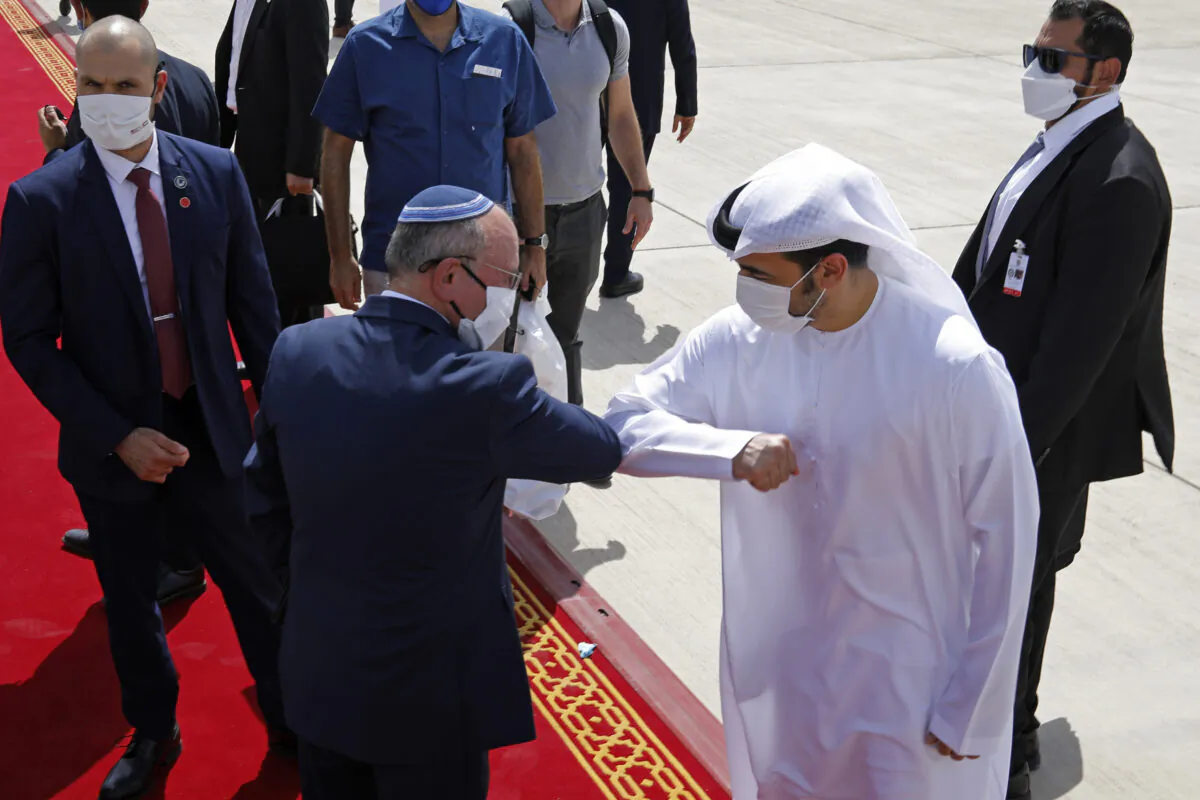 Israeli National Security Adviser Meir Ben-Shabbat, center left, bumps elbows with an Emirati official as he leaves Abu Dhabi, Arab Emirates, on Sept. 1, 2020. (Nir Elias/Pool via AP)