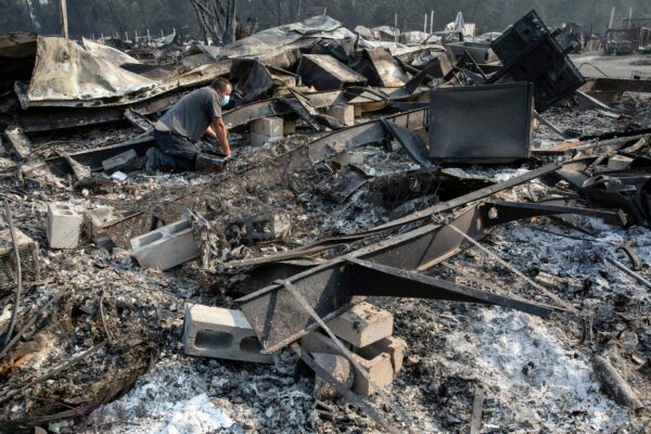 Jon Marshall looks through the debris of his home