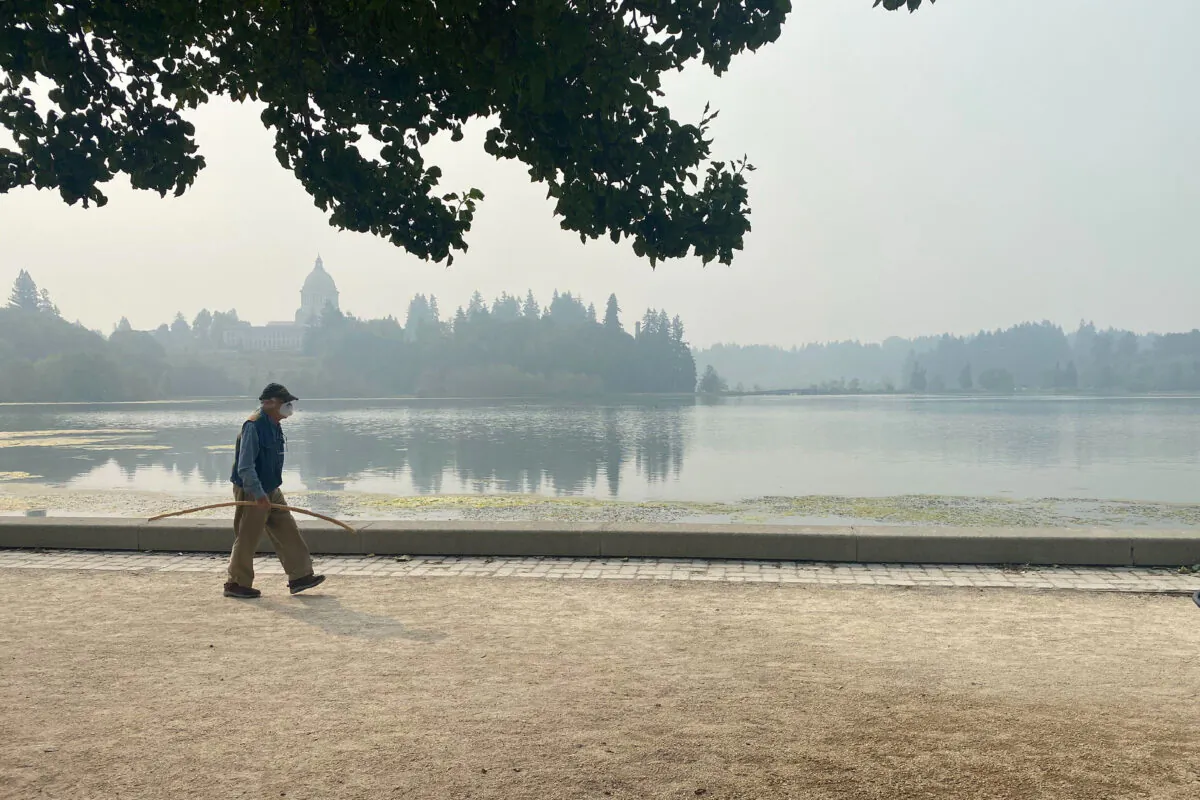 A man walks by the lake outside of the Washington State Capitol in Olympia, Wash., on Sept. 11, 2020. (Rachel La Corte/AP Photo)