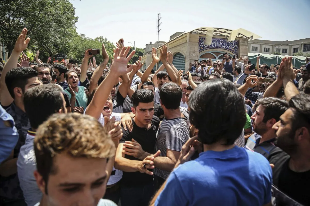 A group of protesters chant slogans at the main gate of the Old Grand Bazaar, in Tehran, Iran on June 25, 2018. (Iranian Labor News Agency via AP)
