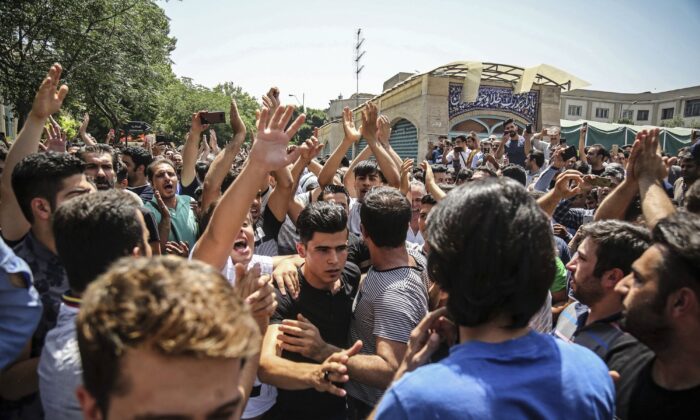 A group of protesters chant slogans at the main gate of the Old Grand Bazaar, in Tehran, Iran on June 25, 2018. (Iranian Labor News Agency via AP)