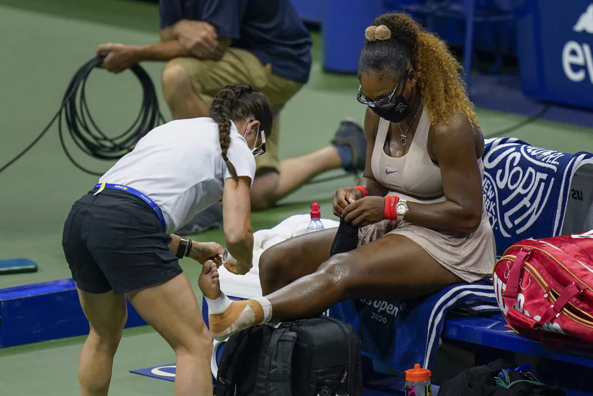 Serena Williams, of the United States, has her ankle taped by a trainer during a medical timeout during a semifinal match of the U.S. Open tennis championships against Victoria Azarenka, of Belarus, Thursday, Sept. 10, 2020, in New York. (Seth Wenig/AP Photo)